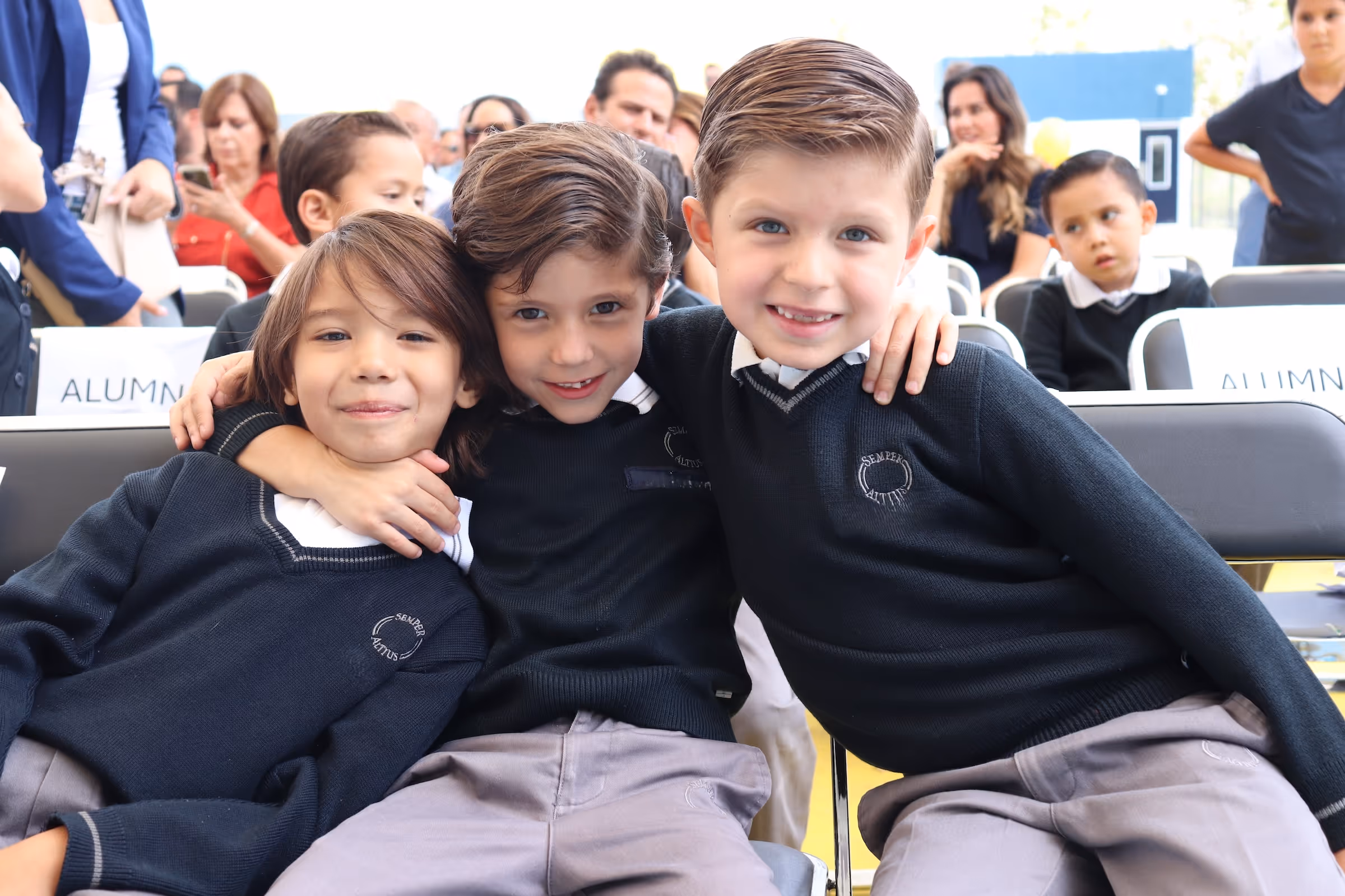 Madre e hija sonriendo en el aula junto a un mapa de México.